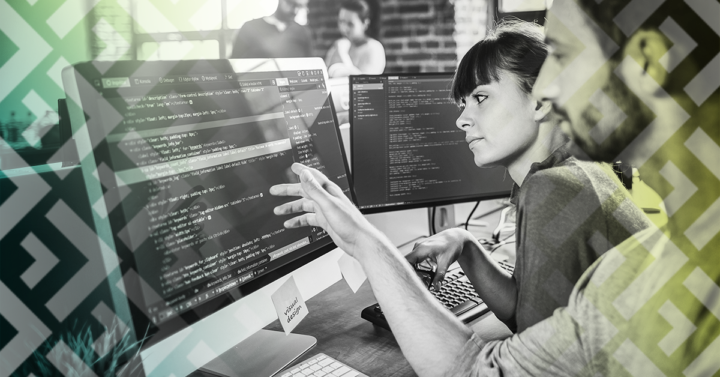 A man and a woman reviewing a code in a computer