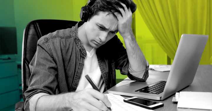 A men studying on his desk.